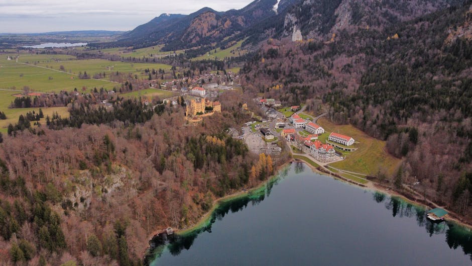 Stunning aerial view of Hohenschwangau and Neuschwanstein Castles surrounded by forest and lake in Schwangau, Germany.